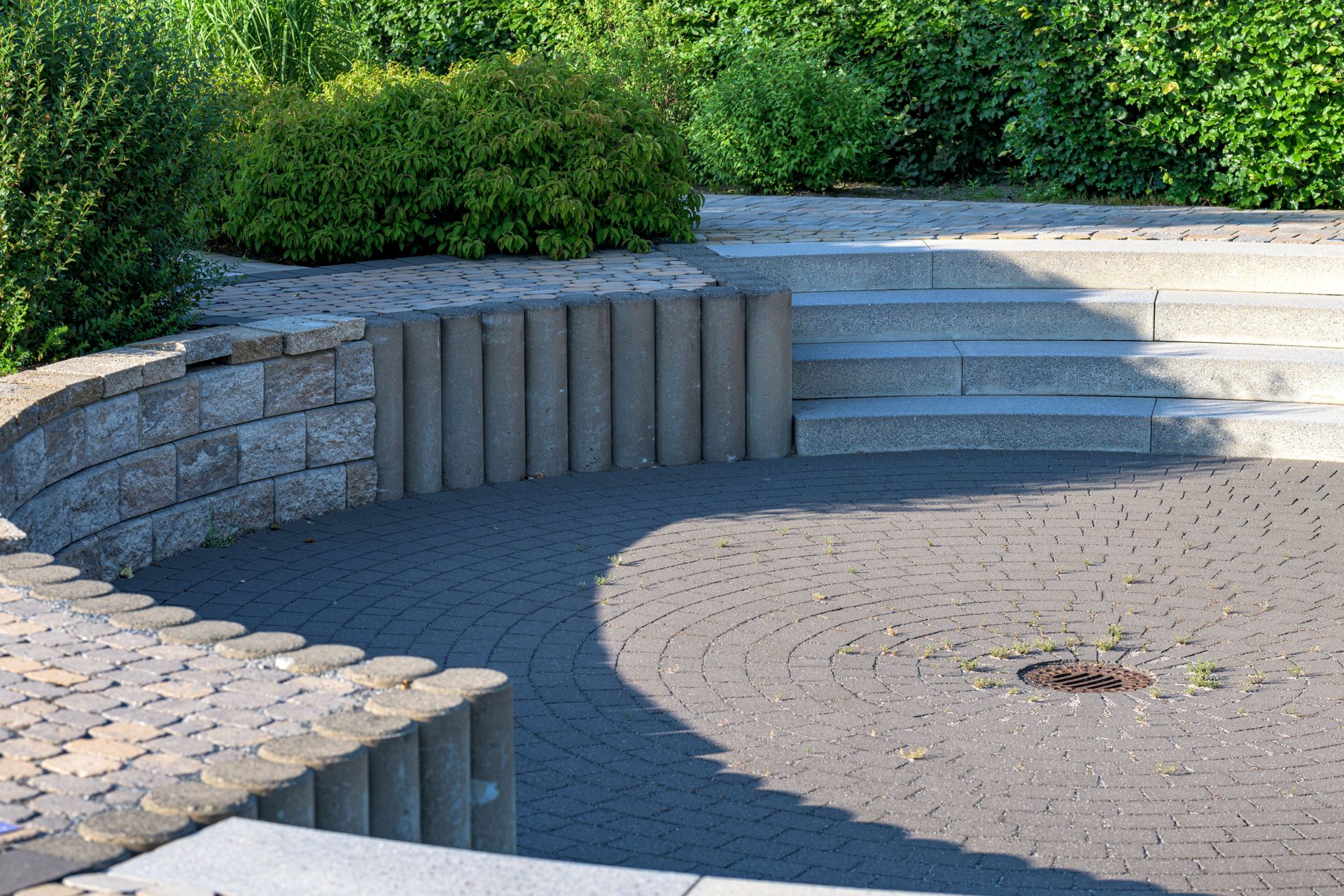 Elegant circular patio with stone steps and lush greenery, Coesfeld, Germany.